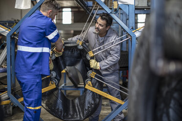 Zwei Reifenreparateure arbeiten zusammen in einer Fabrik - ZEF11181