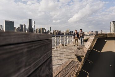 USA, New York City, zwei Geschäftsleute gehen am East River entlang - UUF08853