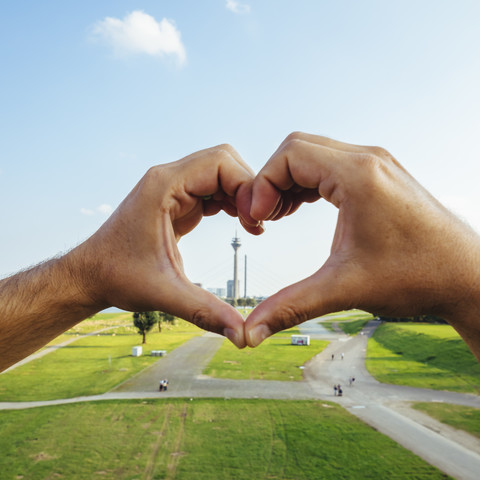 Deutschland, Düsseldorf, Hände bilden ein Herz und umrahmen den Rheinturm, lizenzfreies Stockfoto
