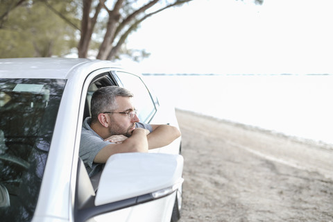 Mann sitzt im Auto und macht eine Pause, lizenzfreies Stockfoto