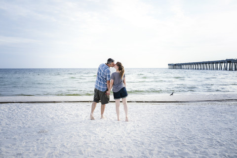 USA, Küssendes Paar am Strand von Panama City, lizenzfreies Stockfoto