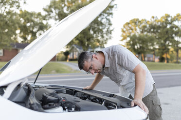 Man checking his car standing at the road side - SHKF00716