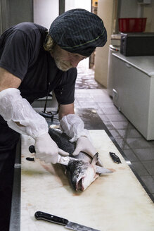 Fischräucherer bereitet Lachs zum Räuchern vor - ABZF01455