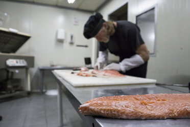 Fischräucherer bereitet Lachs zum Räuchern vor - ABZF01457