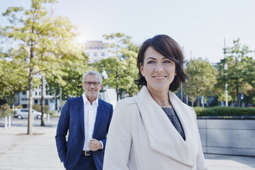Portrait of smiling businesswoman with businessman in background - RORF00382