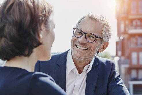 Businessman and businesswoman talking outdoors - RORF00406