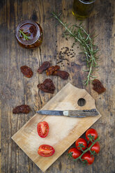 Glass of pickled dried tomatoes and ingredients on wood - LVF05531