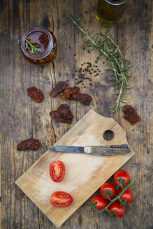 Glas mit eingelegten getrockneten Tomaten und Zutaten auf Holz - LVF05531