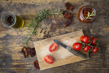 Glass of pickled dried tomatoes and ingredients on wood - LVF05533