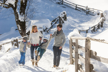 Happy family walking in snow - HHF05458