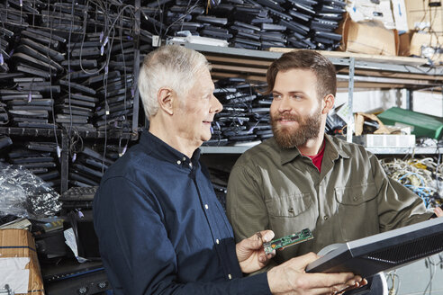 Menschen arbeiten im Lager der Computer-Recyclinganlage - RKNF00379