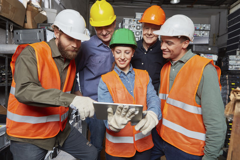 Arbeiter in einer Computer-Recyclinganlage mit digitalem Tablet, lizenzfreies Stockfoto