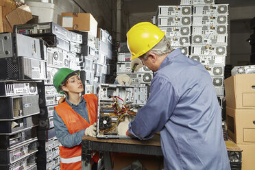 Workers in computer recycling plant dismantling desktop pc - RKNF00401