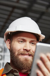 Worker in computer recycling plant using digital tablet - RKNF00405