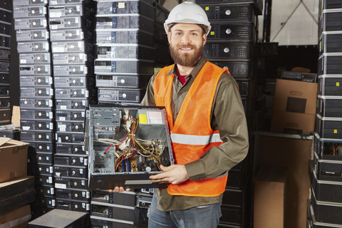 Arbeiter in einer Computer-Recycling-Anlage mit PC-Gehäuse, lizenzfreies Stockfoto