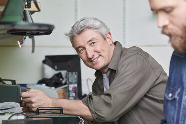 Menschen in der Werkstatt einer Computer-Recyclinganlage - RKNF00465