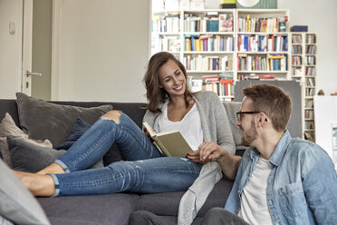 Smiling couple relaxing together in the living room - FMKF03136