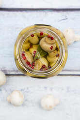 Glass of pickled champignons with red peppercorns and bay leaf, close-up - LVF05547