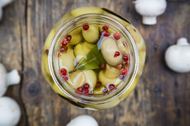 Glass of pickled champignons with red peppercorns and bay leaf, close-up - LVF05553