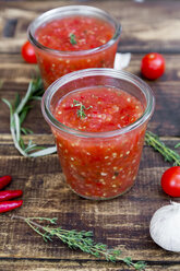 Two glasses of homemade tomato sauce and ingredients on wood - SARF03044