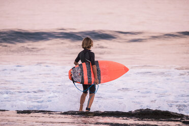 Spain, Tenerife, boy carrying surfboard at the sea - SIPF00995