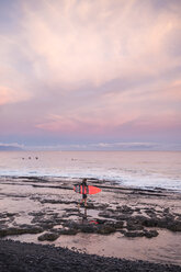 Spanien, Teneriffa, Junge mit Surfbrett am Strand bei Sonnenuntergang - SIPF01006