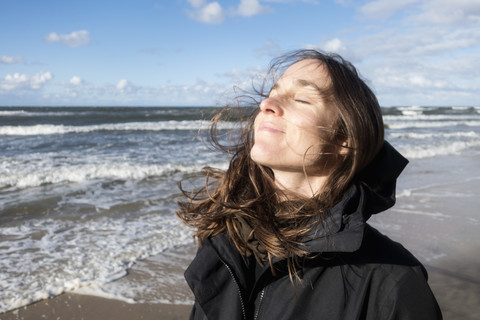 Polen, Misdroy, Frau genießt die Sonne am Strand, lizenzfreies Stockfoto