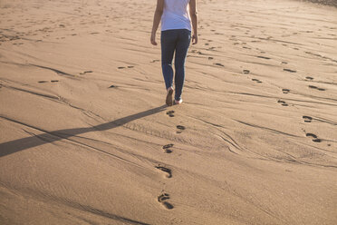 Young woman walking in sand on the beach - SIPF01015