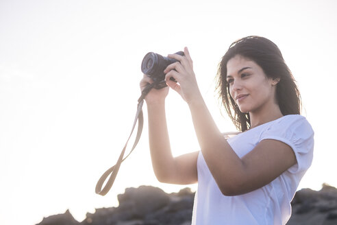 Junge Frau am Strand beim Fotografieren - SIPF01016