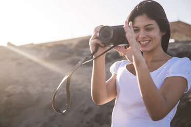 Junge Frau am Strand beim Fotografieren - SIPF01017