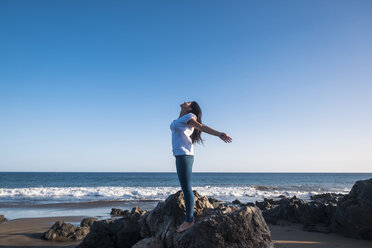 Junge Frau am Strand, die ihre Arme ausstreckt - SIPF01019