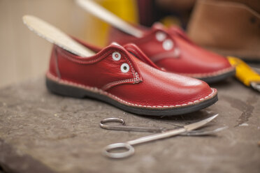 Unfertige rote Schuhe in einer Schuhmacherwerkstatt - ZEF11289