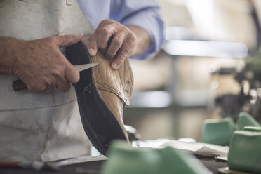 Schuhmacher bei der Arbeit am Schuh in der Werkstatt - ZEF11340