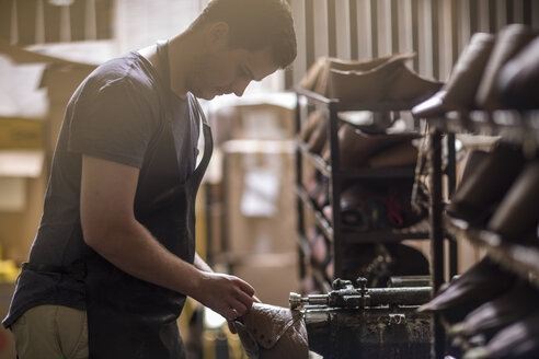 Schuhmacher bei der Arbeit am Schuh in der Werkstatt - ZEF11343