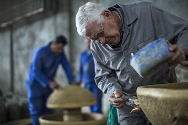 Man working on ceramics in industrial pot factory - ZEF11385