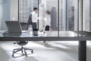 Businessman and woman in meeting discussing in office - ZEF11465