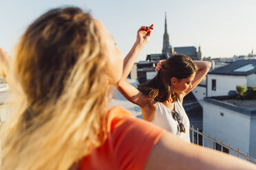 Österreich, Wien, zwei Frauen tanzen auf Dachterrasse - AIF00423