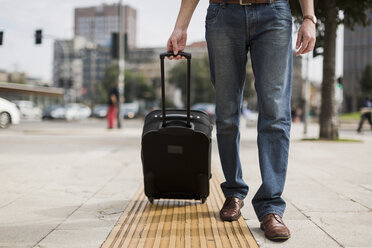 Legs of businessman with suitcase on pavement - MAUF00883