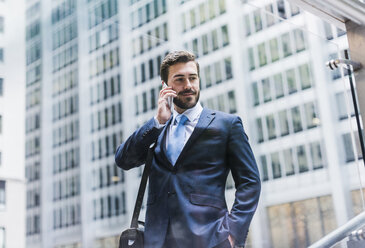 USA, New York City, businessman in Manhattan on cell phone - UUF08935