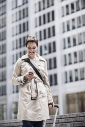 USA, New York City, businesswoman in Manhattan on the go with cell phone - UUF08944