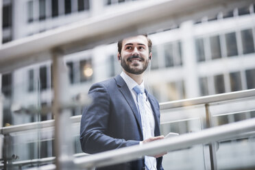 USA, New York City, smiling businessman with earphones - UUF08946