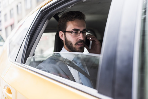 Geschäftsmann telefoniert in einem Taxi, lizenzfreies Stockfoto