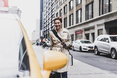 USA, New York City, lächelnde Frau in Manhattan, die sich einem Taxi nähert - UUF08983