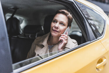 Frau im Taxi telefoniert mit Handy - UUF08984