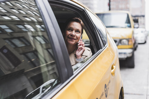 USA, New York City, lächelnde Frau im Taxi am Handy - UUF08985