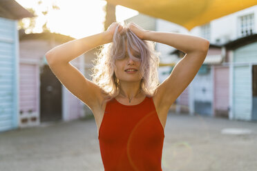 Portrait of young woman with dyed hair wearing red bodysuit - KKAF00008