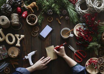 Woman's hands writing on notepad at her desk at Advent - RTBF00475