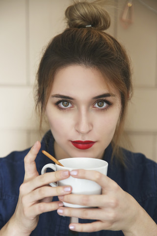 Porträt einer jungen Frau mit einer Tasse Kaffee, lizenzfreies Stockfoto