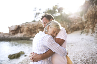 Happy senior couple hugging on the beach - HAPF01022