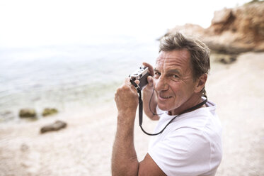 Porträt eines älteren Mannes, der am Strand fotografiert - HAPF01046